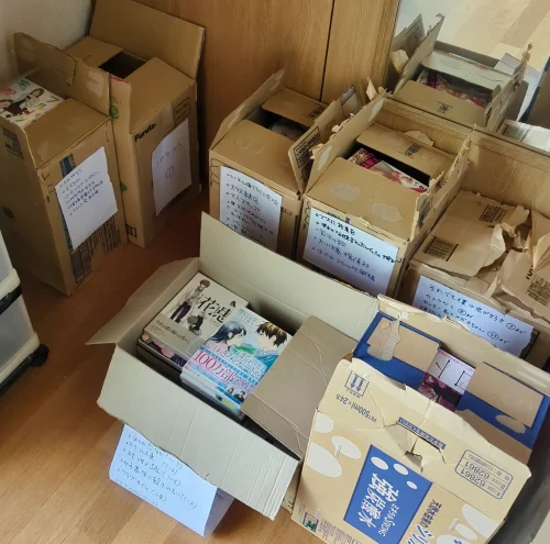 青森市滝沢の出張買取前に作品ごとに整理されたコミックの段ボール